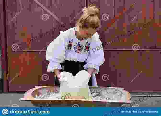 An Elderly Woman, Dressed In Traditional Clothing, Kneading Dough In A Kitchen. My Life As A Kitchen Witch